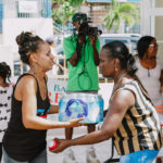 Cane Bay Partners volunteers distribute several thousand pounds of food, hundreds of LUCI solar lights and 6 pallets of water donated by St. Croix Foundation at Zion Christian Academy on Saturday, Nov. 11. Photo credit: Nicole Canegata http://nicolecanegata.com/