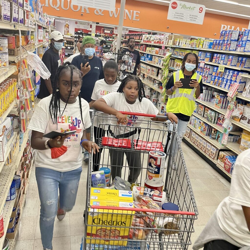 Level Up With Fruits And Veggies Nutrition Fair Participants Race Through The Market STX During A Reinvented 'Supermarket Sweep' Scavenger Hunt For Preteens Hosted By Cane Bay Cares.