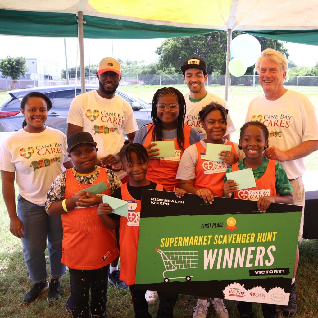 2023 Supermarket Sweep Winners Trevor Noelien, Nial Moorehead, Cherish Abraham, Nhye Griffin, And Adonis Moorehead (front Left To Right) Pose For Photo Along With Cane Bay Partners CEO Jimmy Whatley (back Right) And Cares Volunteers Raydiance Cherubin, Alfred Acquah, And Christian Brady (back Left To Right).